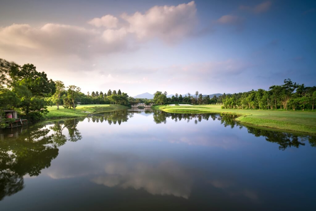 Peaceful golf course landscape with a reflective lake and serene surroundings.